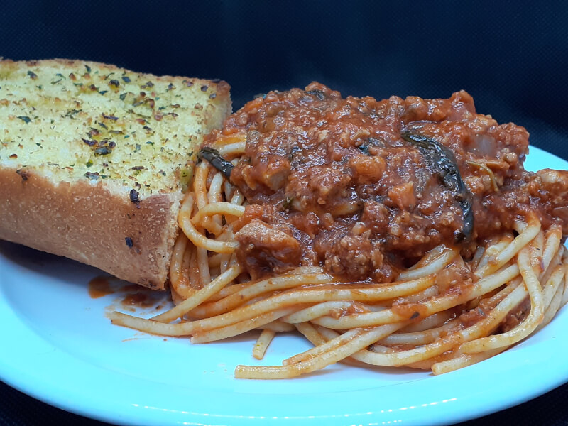 Spaghetti with Sauce on top and Garlic Bread