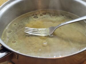 Mashing a Chicken Bouillon Cube in water over the stovetop