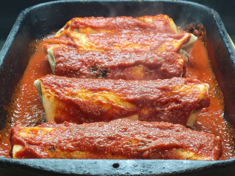 Enchilada Casserole with Enchilada sauce drizzled over Beefy Cheese Burritos