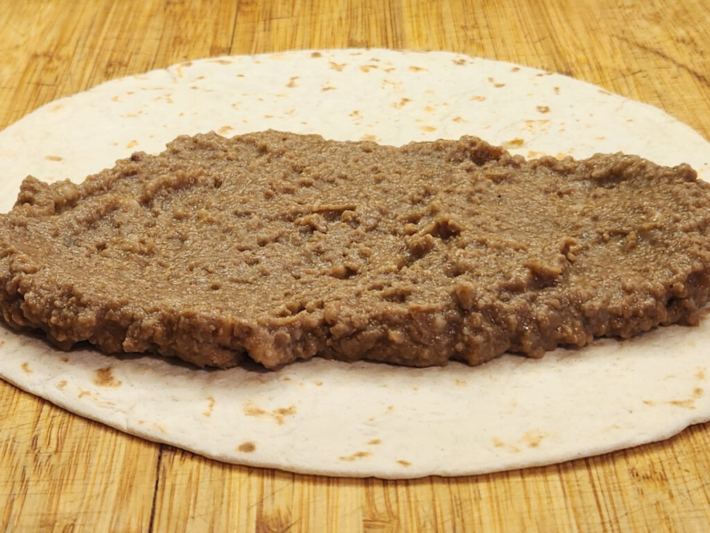 Half a cup of burrito meat on steamed tortilla